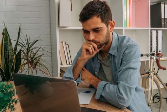 Man,At,Home,With,Computer,Thoughtful,Or,Making,Decision