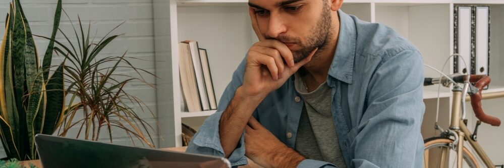 Man,At,Home,With,Computer,Thoughtful,Or,Making,Decision
