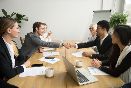 Diverse,Businessmen,Shaking,Hands,After,Signing,Contracts,At,Group,Multiracial